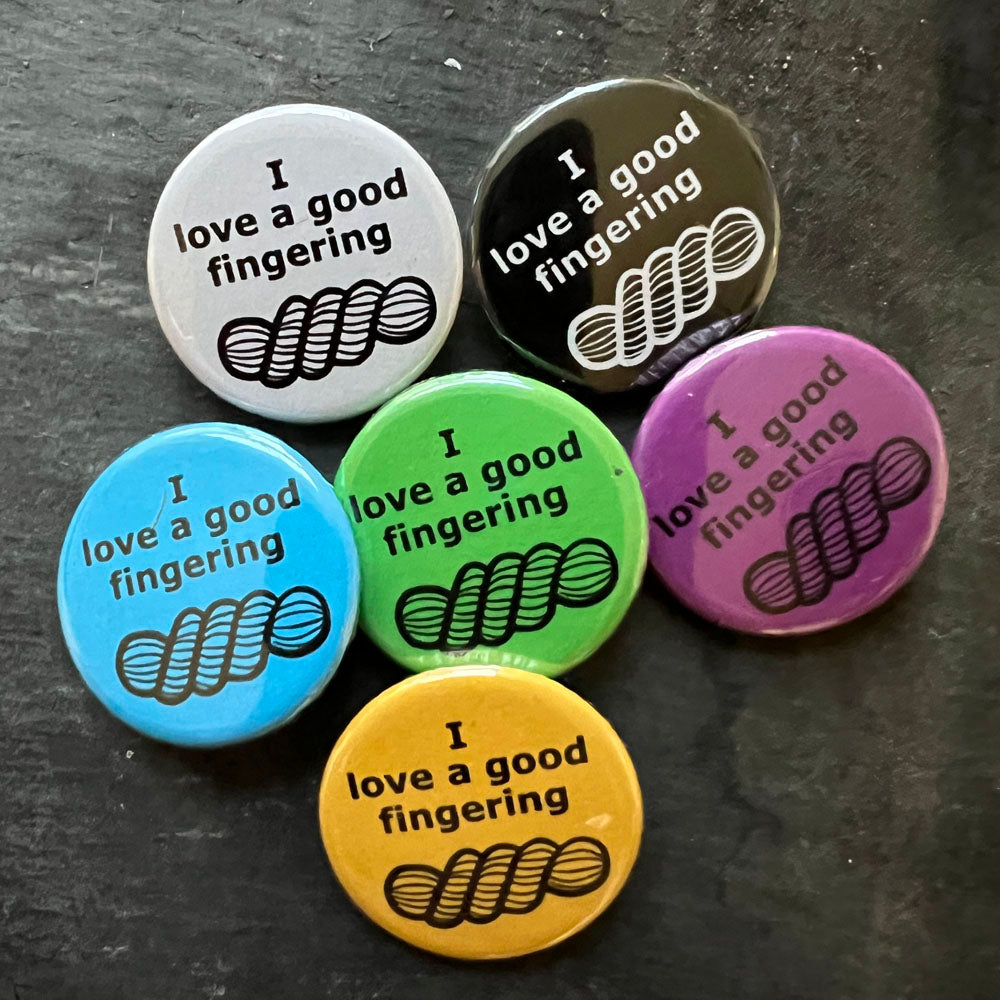 Six I love a good fingering pin badges in black, blue, pink, green, yellow, and white.