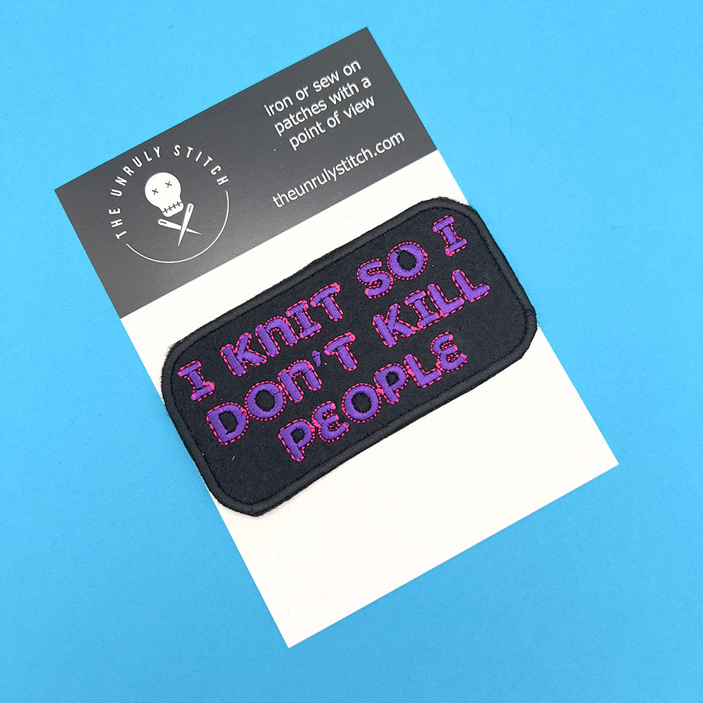 An embroidered felt patch with the text "I KNIT SO I DON'T KILL PEOPLE" in pink and purple letters is displayed on a card. The card features the logo and branding of "The Unruly Stitch" on a blue background.