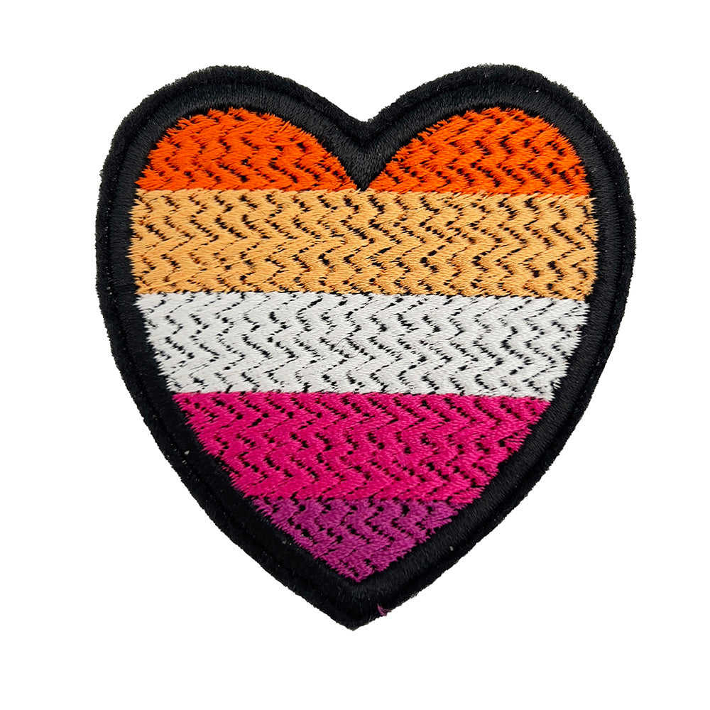A close-up view of a heart-shaped embroidered felt patch featuring the lesbian pride flag colors: dark orange, orange, white, pink, and dark pink stripes.
