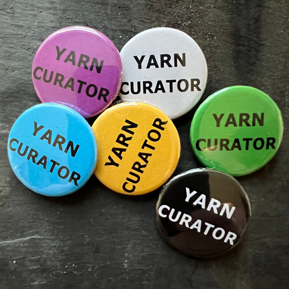 Six YARN CURATOR pin badges in black, blue, pink, green, yellow, and white.