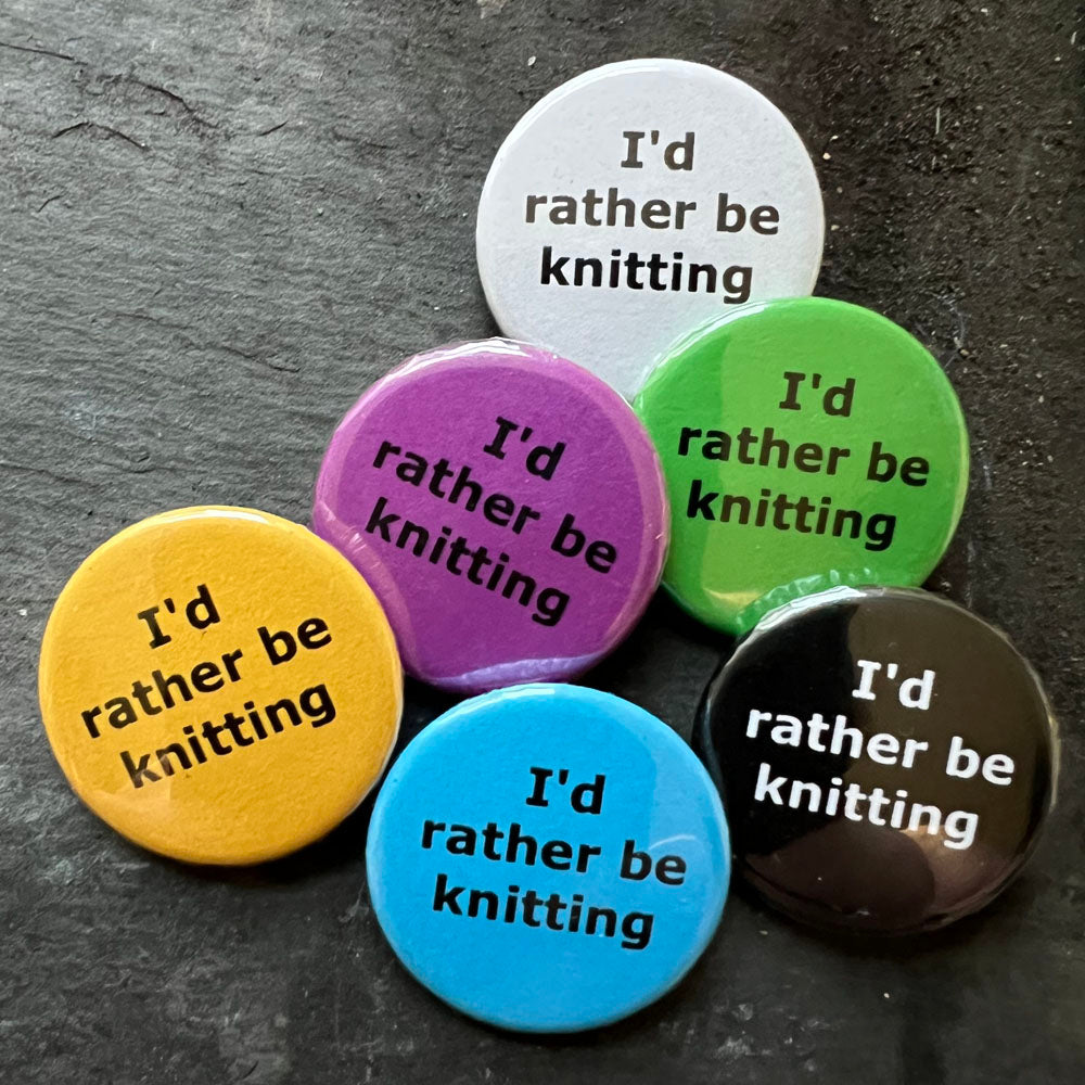 Six I'd rather be knitting pin badges in black, blue, pink, green, yellow, and white.