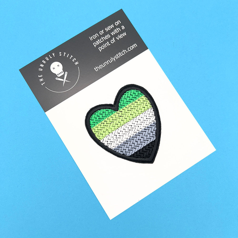 Aromantic Pride flag heart-shaped embroidered felt patch displayed on a branded card from The Unruly Stitch, ready for sale.