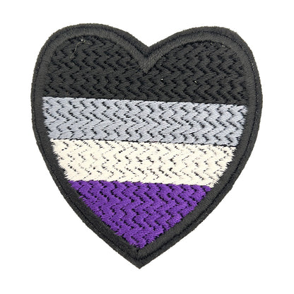 Close-up view of a heart-shaped embroidered felt patch featuring the Asexual Pride flag colors in black, gray, white, and purple from The Unruly Stitch.