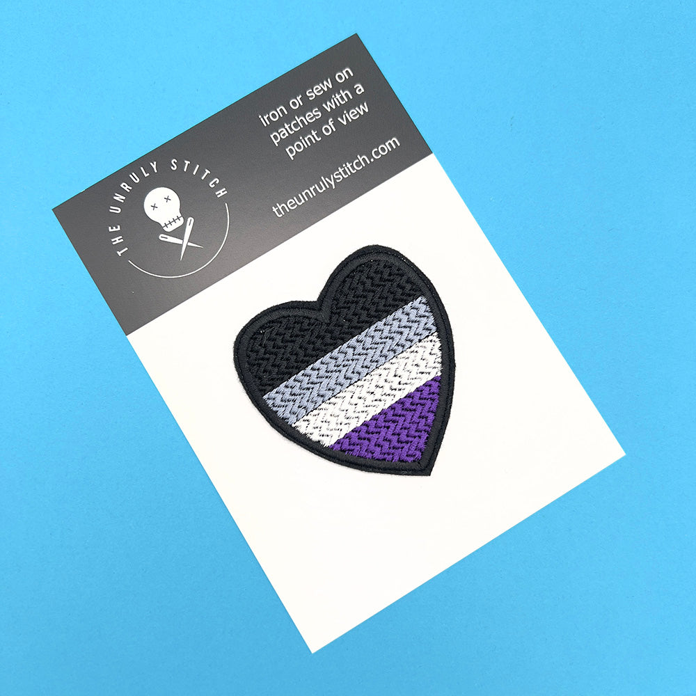 Asexual Pride flag heart-shaped embroidered felt patch displayed on a branded card from The Unruly Stitch