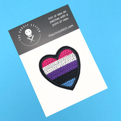 Gender fluid pride flag heart-shaped embroidered felt patch displayed on a branded card with "The Unruly Stitch" logo. The patch features horizontal stripes in pink, white, purple, black, and blue.
