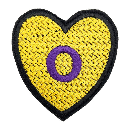 Close-up view of a heart-shaped embroidered patch featuring the Intersex Pride flag design, with a yellow background and a purple circle.