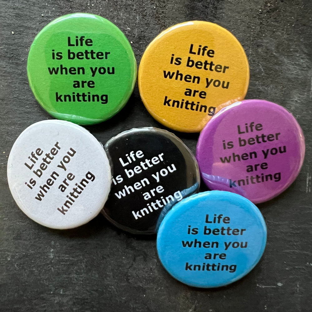 Six Life is better when you are knitting pin badges in black, blue, pink, green, yellow, and white.