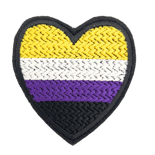 A close-up view of a heart-shaped embroidered felt patch featuring the non-binary pride flag colors: yellow, white, purple, and black stripes.