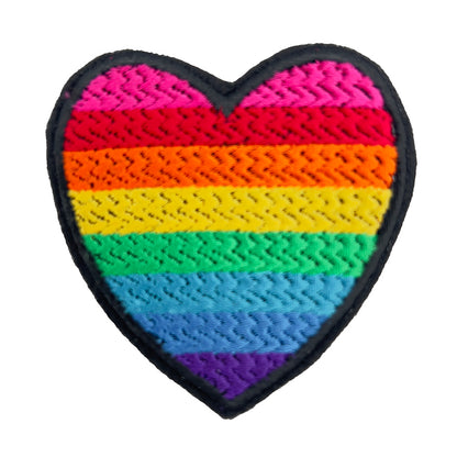 A heart-shaped embroidered patch with the rainbow colors of the original gay pride flag. The patch is displayed against a plain white background.