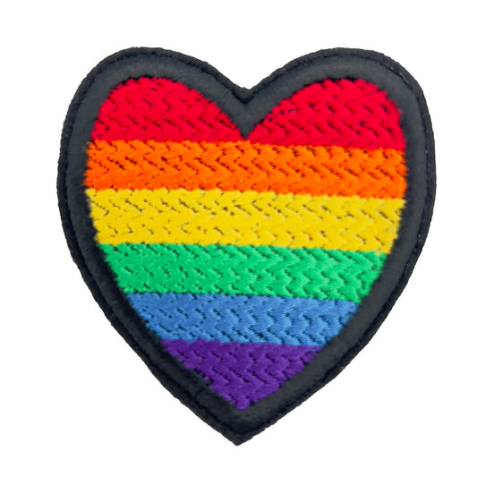 Close-up of a heart-shaped embroidered felt patch with the rainbow pride flag colors (red, orange, yellow, green, blue, purple) on a white background.