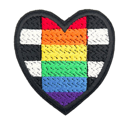 Close-up of a heart-shaped embroidered felt patch with the straight allies pride flag design, featuring black and white stripes with a rainbow triangle in the center, on a white background.