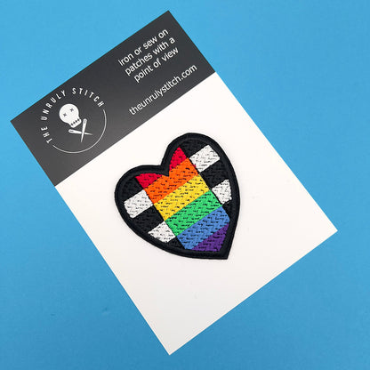 Heart-shaped straight allies pride flag patch on a white card with "The Unruly Stitch" branding, set against a blue background.