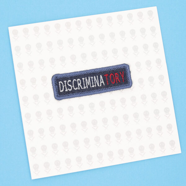 gift card with blue denim patch embroidered with the word DISCRIMINATORY