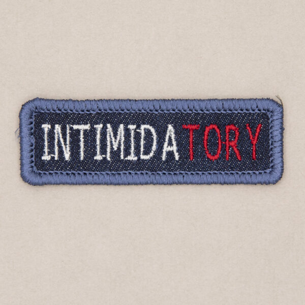 blue denim patch embroidered with the word INTIMIDATORY