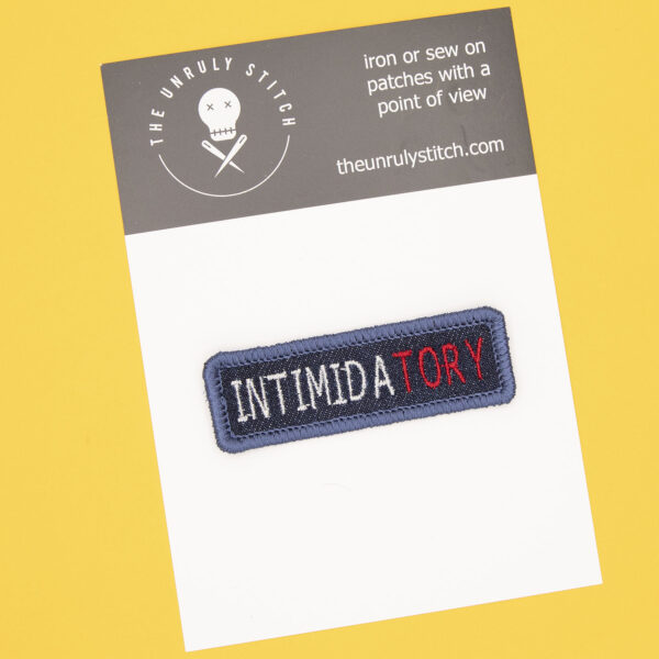 postcard with blue denim patch embroidered with the word INTIMIDATORY