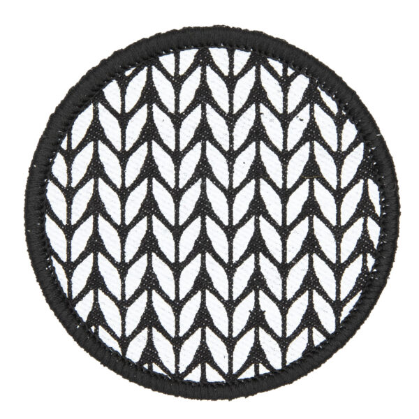 patch made from black denim screen printed with a stocking stitch print and finished with an embroidered border