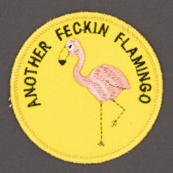 round embroidered patch picture of pink flamingo and text another feckin flamingo on yellow