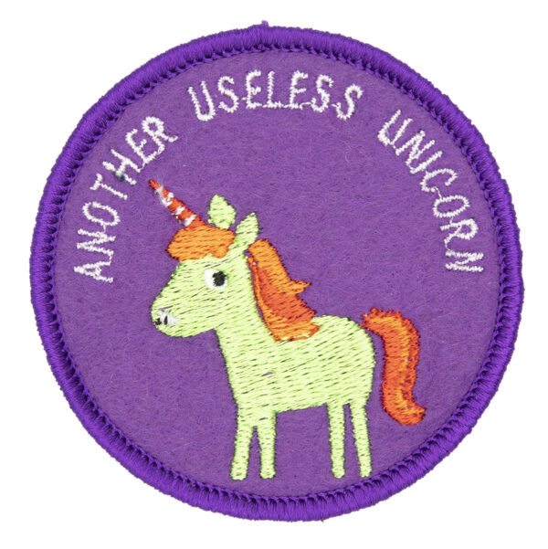 round embroidered patch picture of a green unicorn and text another useless unicorn on purple