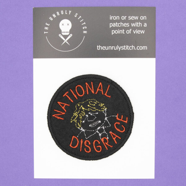 round embroidered patch line drawing of Boris Johnson and the words National Disgrace