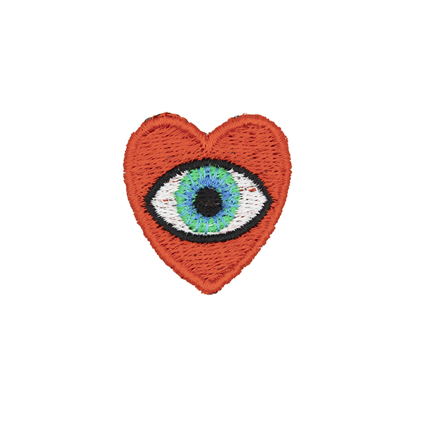 small embroidered patch, red heart containing a brown eye photographed on a white background