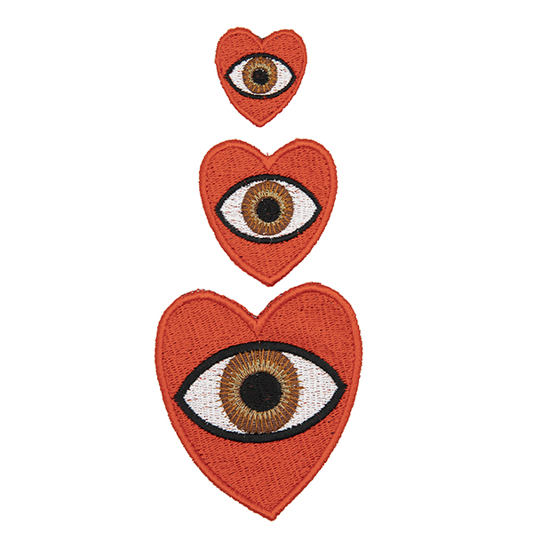 three embroidered patches, all read hearts with brown eye in the centre. Patches are large, medium and small. Displayed in a vertical line on a white background.