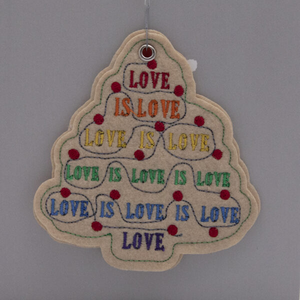 cream felt ornament, Christmas tree shape embroidered with LOVE IS LOVE in pride rainbow colours and red fairy lights