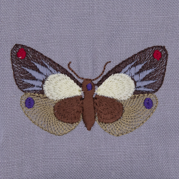 close up of silver linen moth repellant bag. Embroidered moth has wings open.