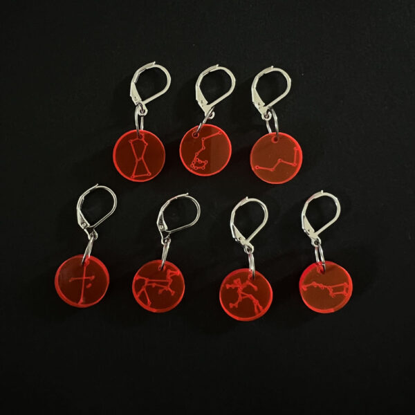 Seven constellations on discs laser cut from fluorescent red perspex. Mounted on a latch back hooks to create stitch markers.