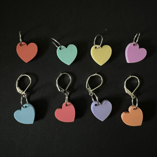 Eight hearts laser cut from eight colours of pastel perspex. Mounted on a mix of jump rings and latch back hooks to create stitch markers.