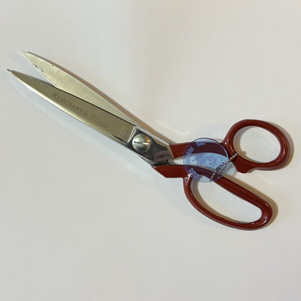 Dressmaking scissors held closed by the metal chain of scissor savers. The scissors are slightly open, showing how movement is limited.