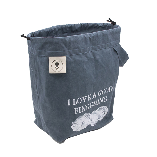 side view or small slate blue drawstring project bag. The bag is printed with text "I LOVE A GOOD FINFERING" and a skein of yarn in white ink. The bag has a handle, a drawstring and a cream label with The Unruly Stitch logo
