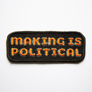 Making is political embroidered patch in orange and turquoise on black felt.