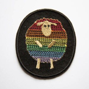 Rainbow striped sheep patch embroidered on black felt.