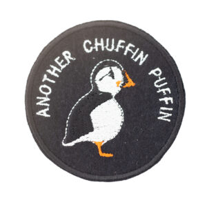 Embroidered patch on black felt showing a puffin. Text reads " ANOTHER CHUFFIN PUFFIN" . Shown on a white background.