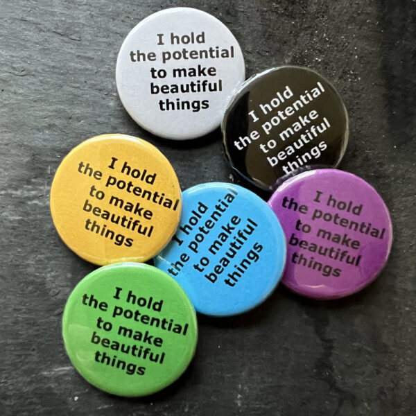 Six badges with the words I hold the potential to make beautiful things. Black text on blue, yellow, green, pink and white, white text on black background.