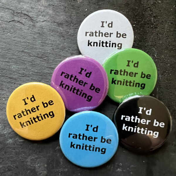 Six badges with the words I'd rather be knitting Black text on blue, yellow, green, pink and white, white text on black background.
