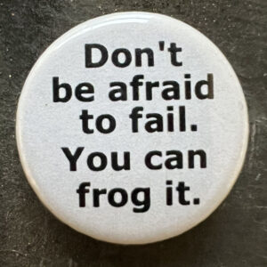 Pin badge with the words Don't be afraid to fail. You can frog it. Black text, white background.