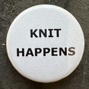 Pin badge with the words KNIT HAPPENS. Black text, white background.