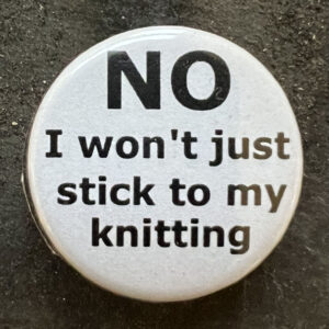 Pin badge with the words NO I won't just stick to my knitting. Black text, white background.