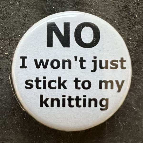 Pin badge with the words NO I won't just stick to my knitting. Black text, white background.