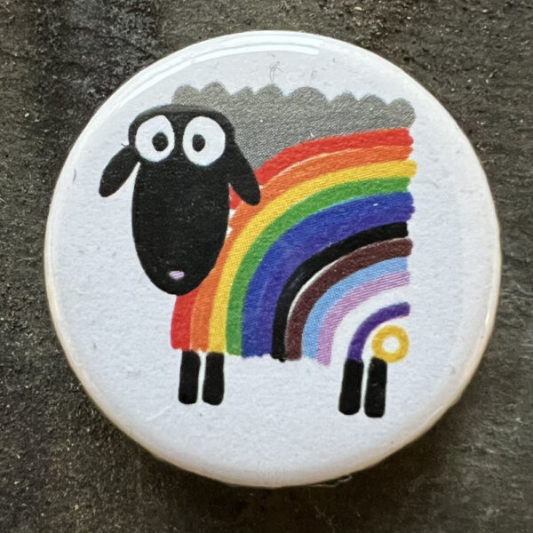 Pin badge with the cartoon sheep in inclusive pride flag stripes on a white background.