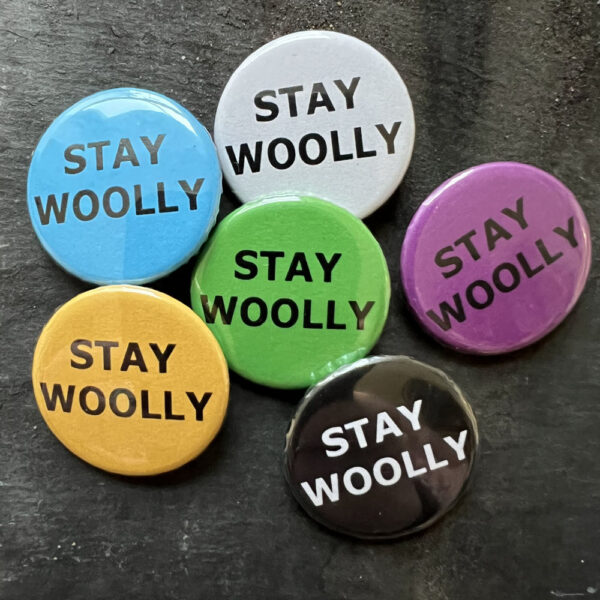 Six badges with the words STAY WOOLY. Black text on blue, yellow, green, pink and white, white text on black background.