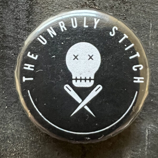 Pin badge with The Unruly Stitch logo White text and image lines, black background.
