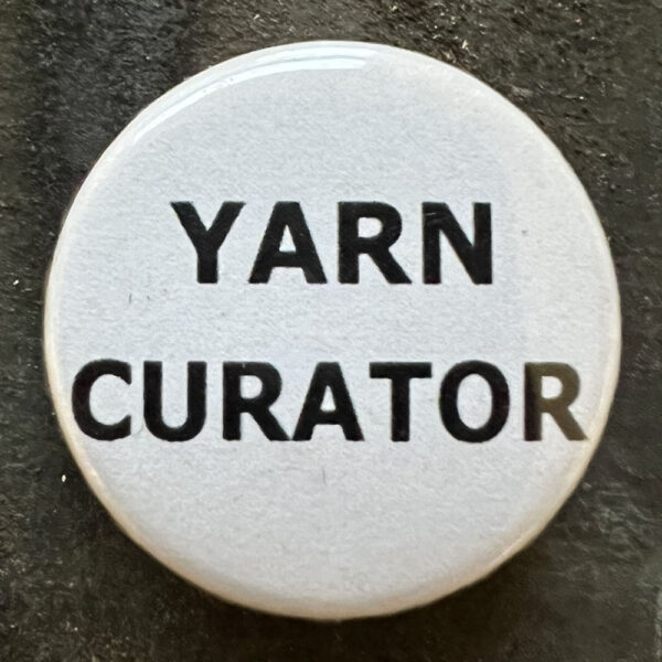 Pin badge with the words YARN CURATOR. Black text, white background.